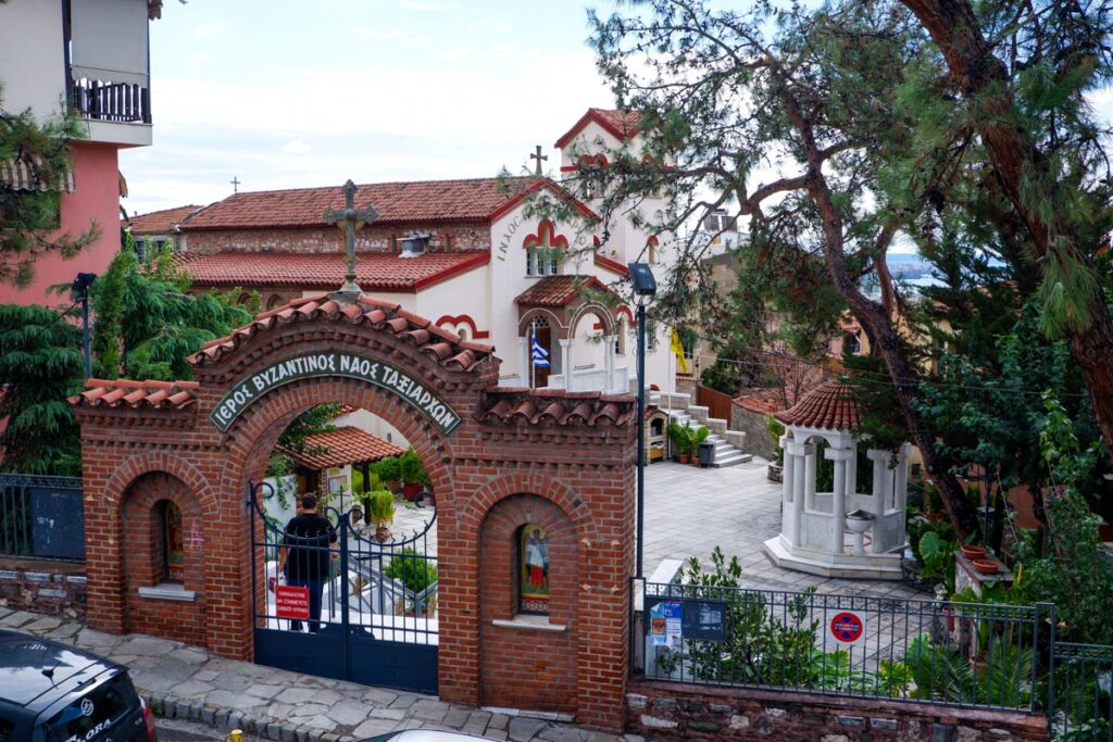 A bright red entry gate to the Holy Church of the All-Great Taxiarchs in Thessaloniki, Greece