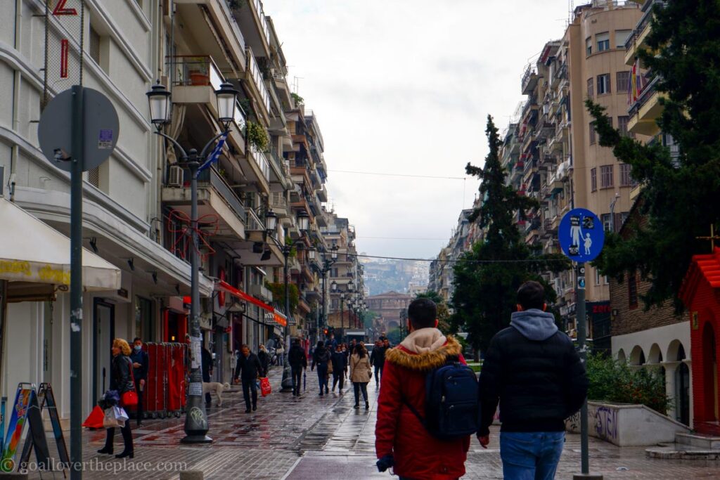 2 people walk down a street in downtown Thessaloniki in Thessaloniki, Greece